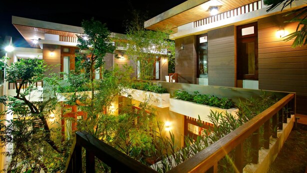 A modern hotel with multiple levels, outdoor terraces, and well-lit pathways. - Hanging Garden Hoi An (Da Nang)
