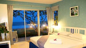 Un dormitorio con cama, escritorio y vistas al océano.