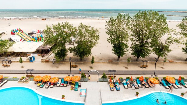 A pool area with a view of the beach and ocean. - Hotel Bavaria Blu (Constanta)