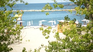 A beach with umbrellas and a lifeguard tower. - Hotel Bavaria Blu (Constanta)