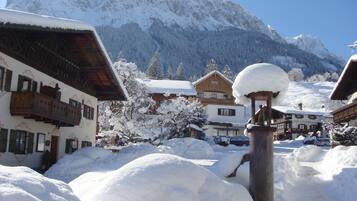 A snow-covered village with traditional wooden buildings and a mountain backdrop.