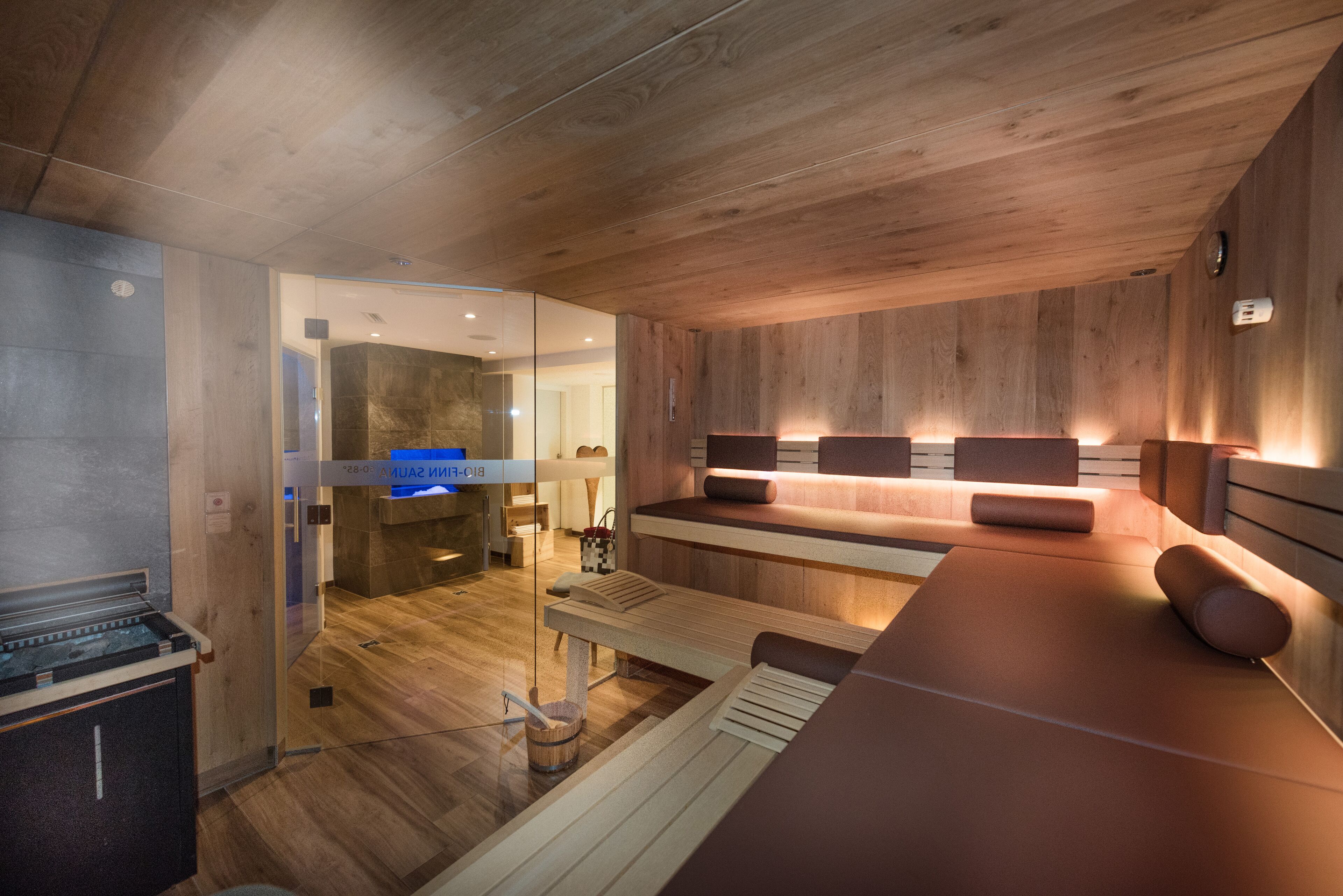 Une salle de spa moderne avec un lambris en bois, un comptoir d’accueil et une table de massage.