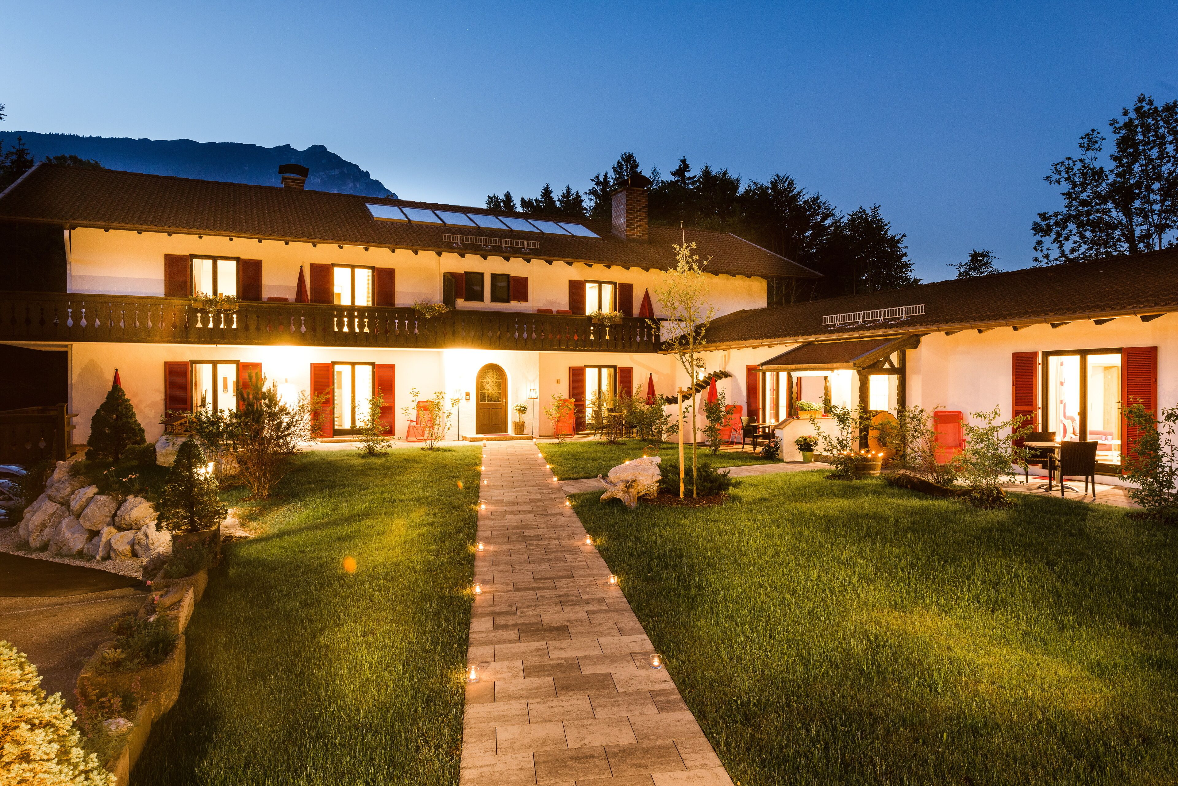 A two-story building with a central entrance, a covered patio area, and a well-maintained lawn.
