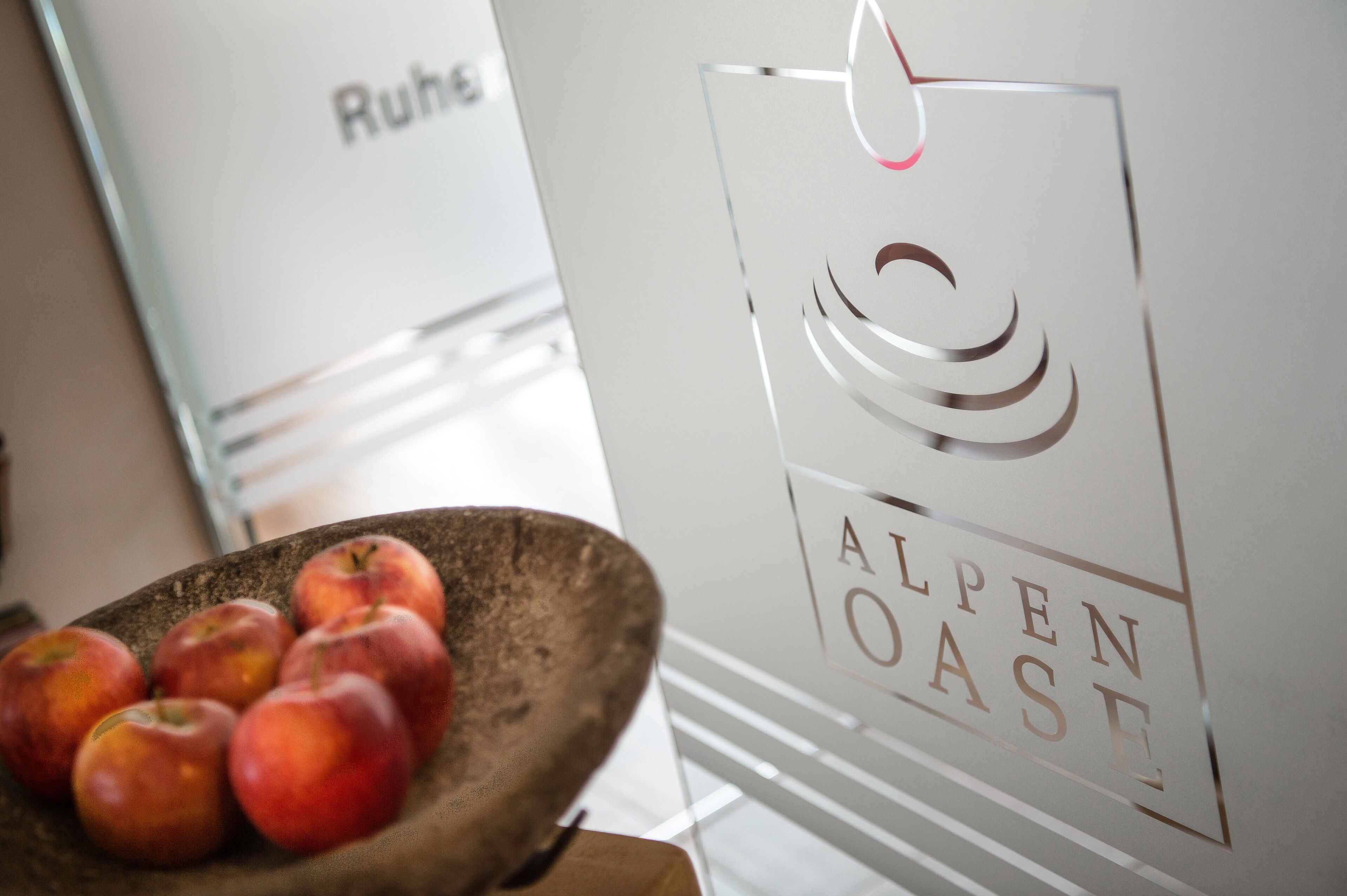A bowl of apples and a sign with the text "ALPEN OASE".