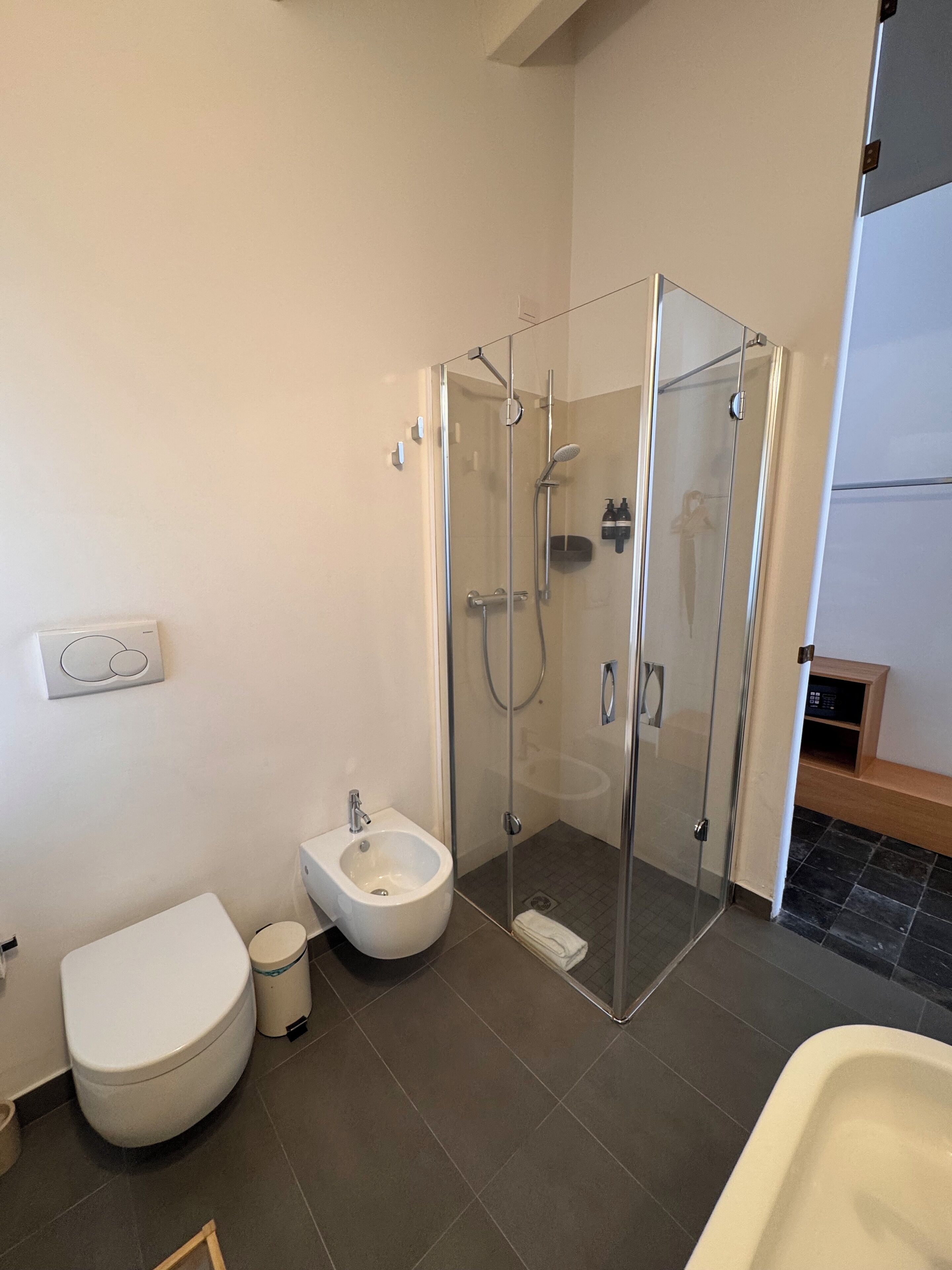 Et moderne badeværelse med bruseniche, toilet, badekar og en bidet.
