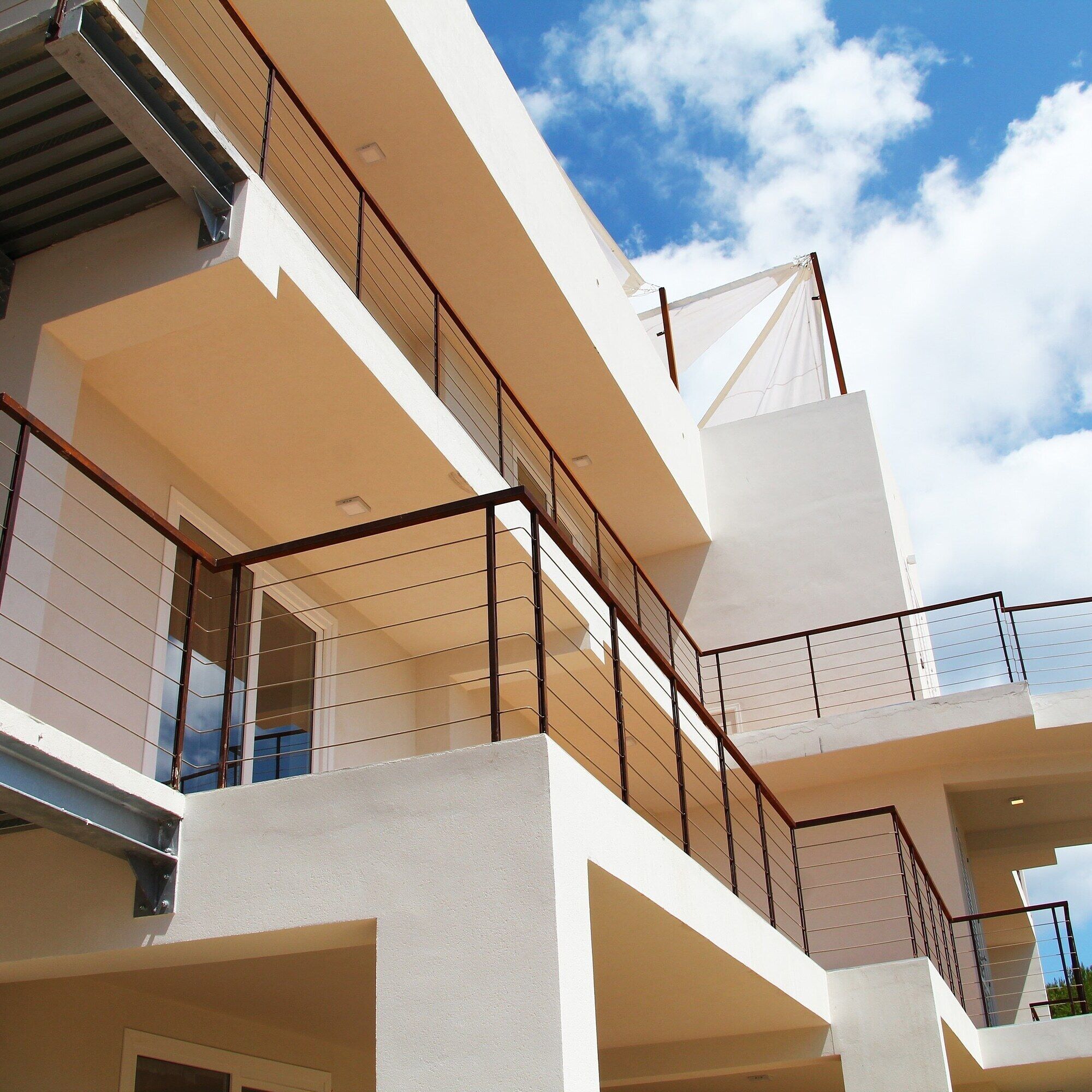 Un edificio de varios pisos con balcones y barandillas.