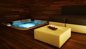 A wooden cabin with a hot tub and a yellow ottoman. - Resort Il Mulino (Favignana)