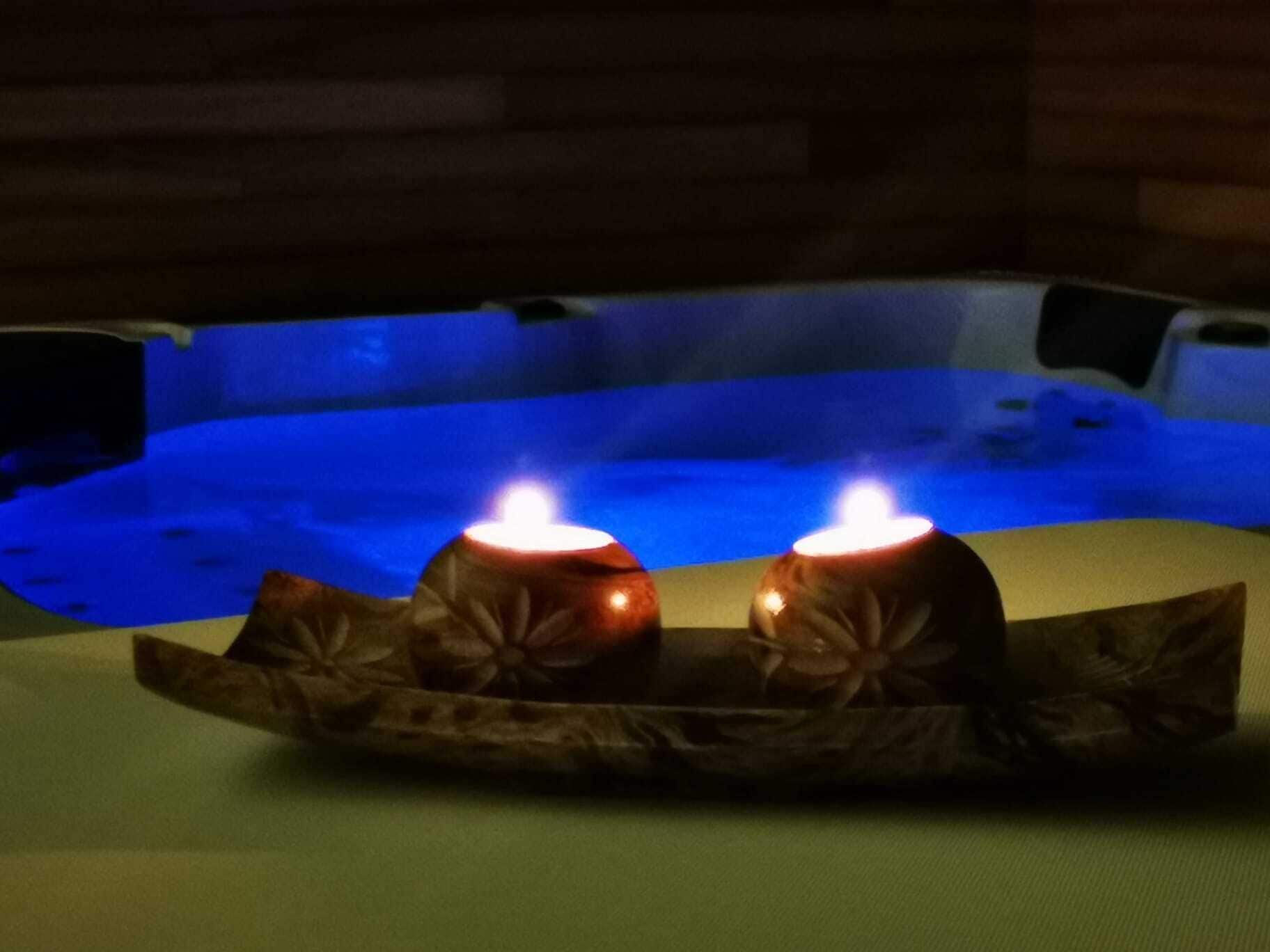 Un jacuzzi con dos velas encendidas sobre una bandeja.