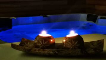 Un jacuzzi con dos velas encendidas sobre una bandeja.