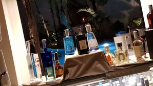 A bar area with a variety of liquor bottles displayed on a table. - Resort Il Mulino (Favignana)