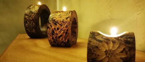 Three wooden candle holders with intricate carvings on a wooden surface.