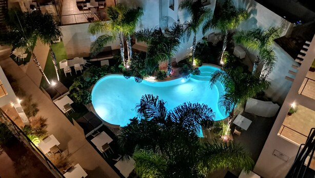 An indoor swimming pool surrounded by lounge areas and greenery. - Resort Il Mulino (Favignana)