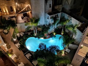 An indoor swimming pool surrounded by lounge areas and greenery. - Resort Il Mulino (Favignana)