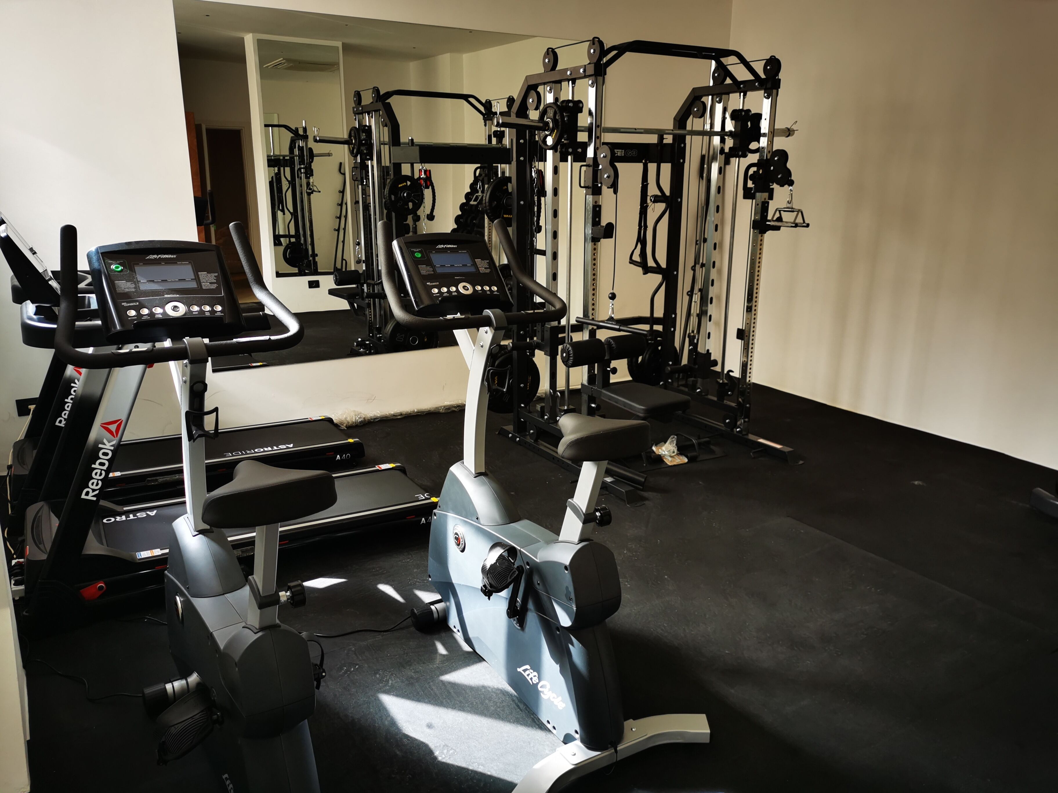 Ett gym med löpband, crosstrainers och utrustning för styrketräning.