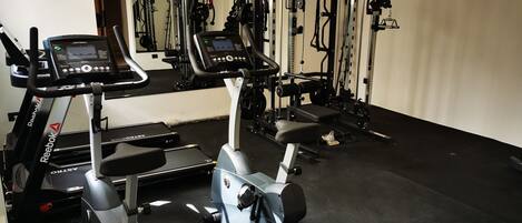 Ett gym med löpband, crosstrainers och utrustning för styrketräning.