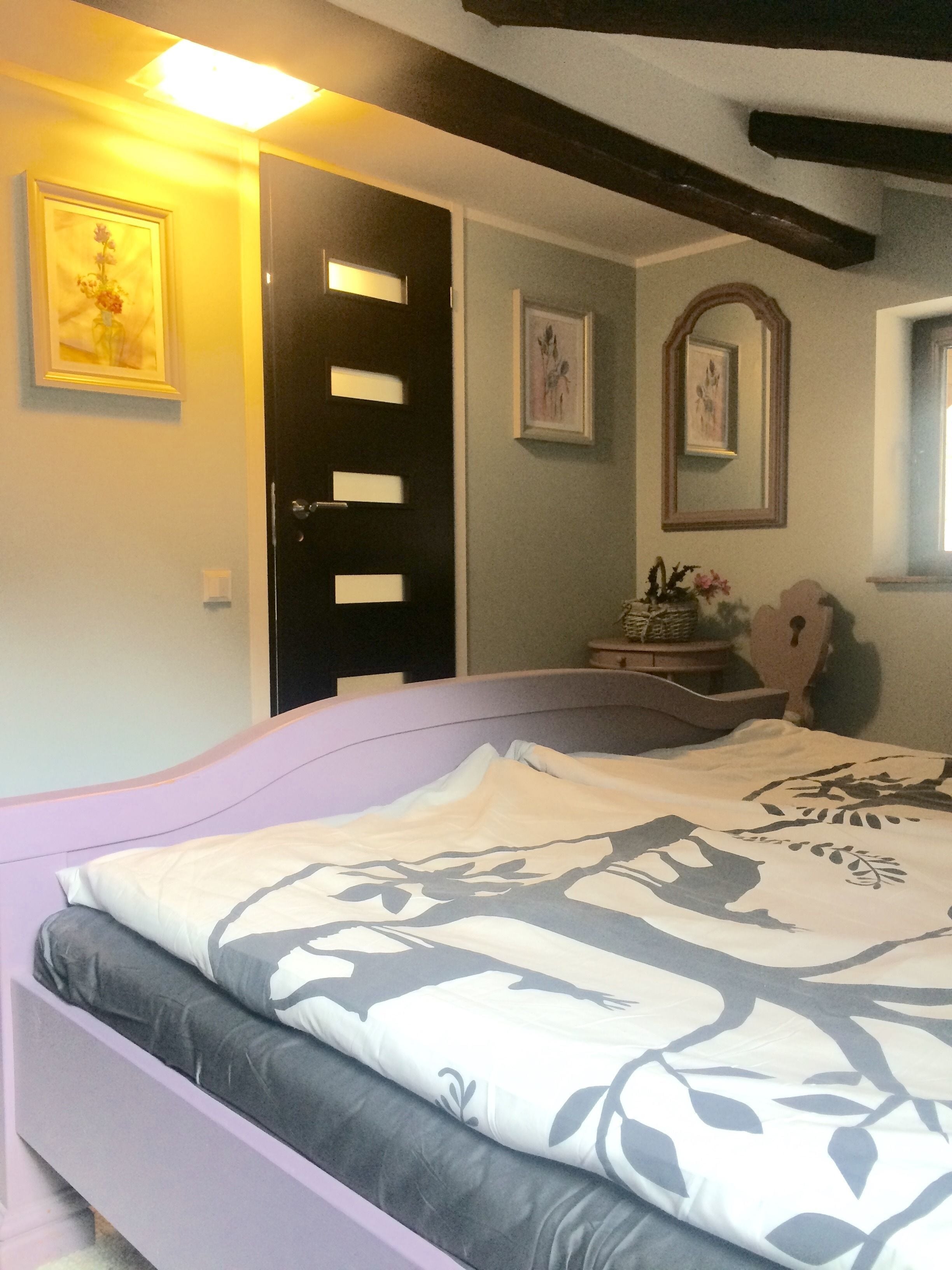 Un dormitorio con cama, cómoda, espejo y puerta.