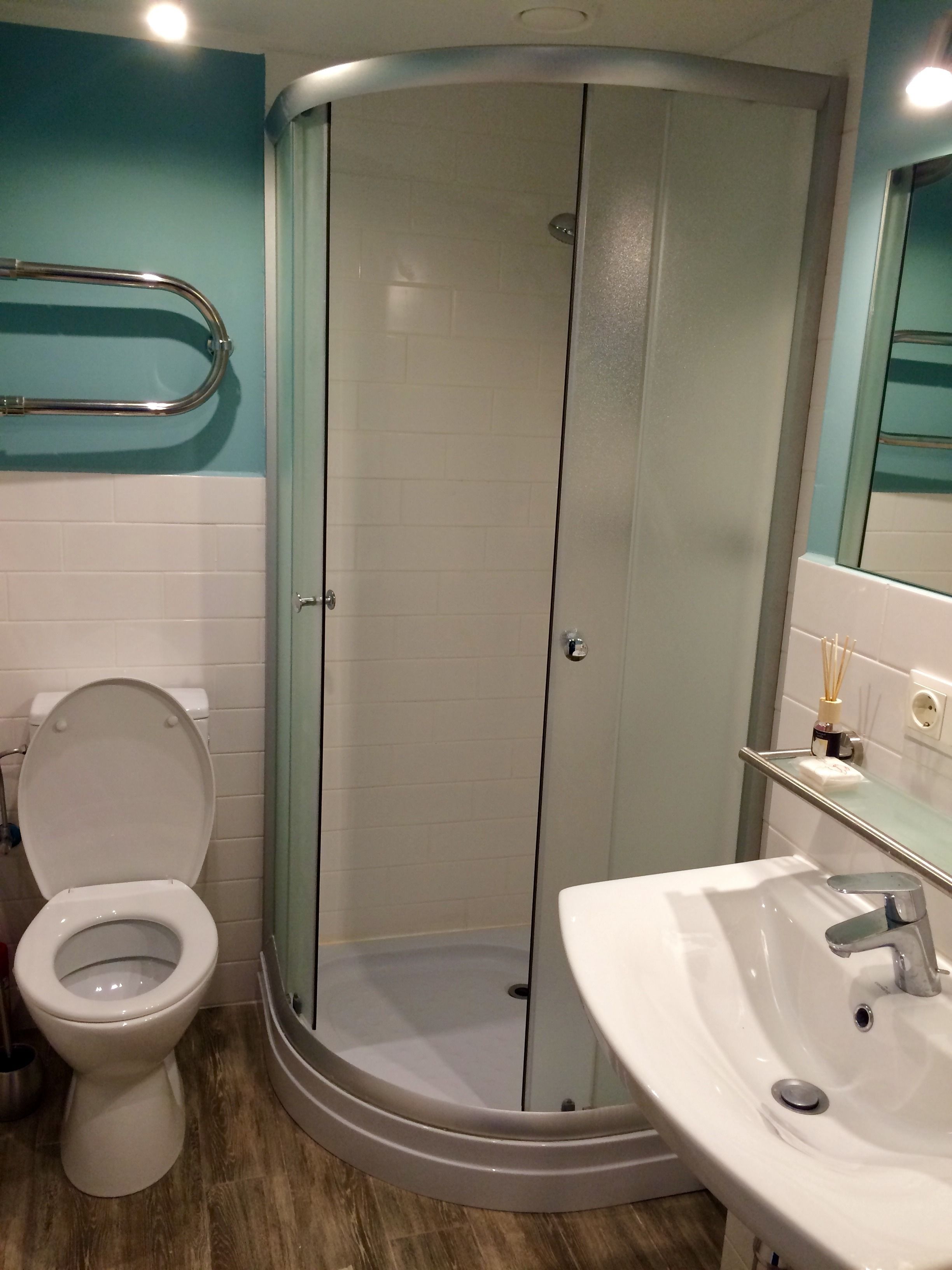 A bathroom with a toilet, a glass-enclosed shower, and a sink.