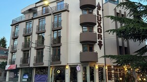 Un hotel de varios pisos con un llamativo letrero 'LUXURY', balcones y un diseño arquitectónico moderno.