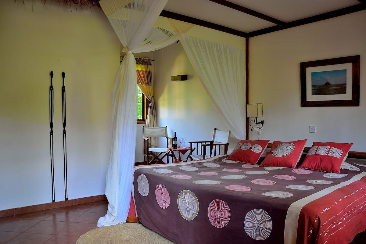 A bedroom with a bed, a desk, and a chair.