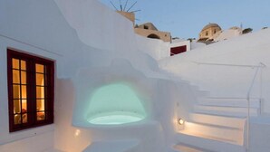 A white-washed building with a circular skylight and a staircase leading to a door. - The Architect's Cave House (Santorini)