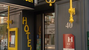 Entrada de un hotel con un letrero que dice "HOTEL LA PERGOLA" y el número "40" en la pared.