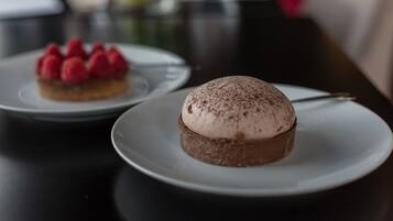 Two desserts on white plates on a table.