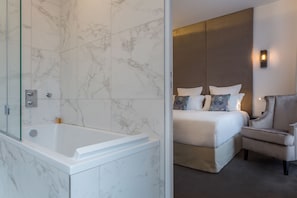 A modern bathroom with a glass-enclosed shower and a white bathtub.