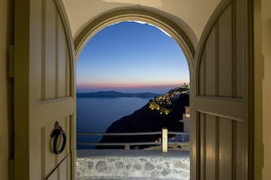 Un arco de entrada que da a una vista costera, con un muro de piedra y una barrera de cuerda.