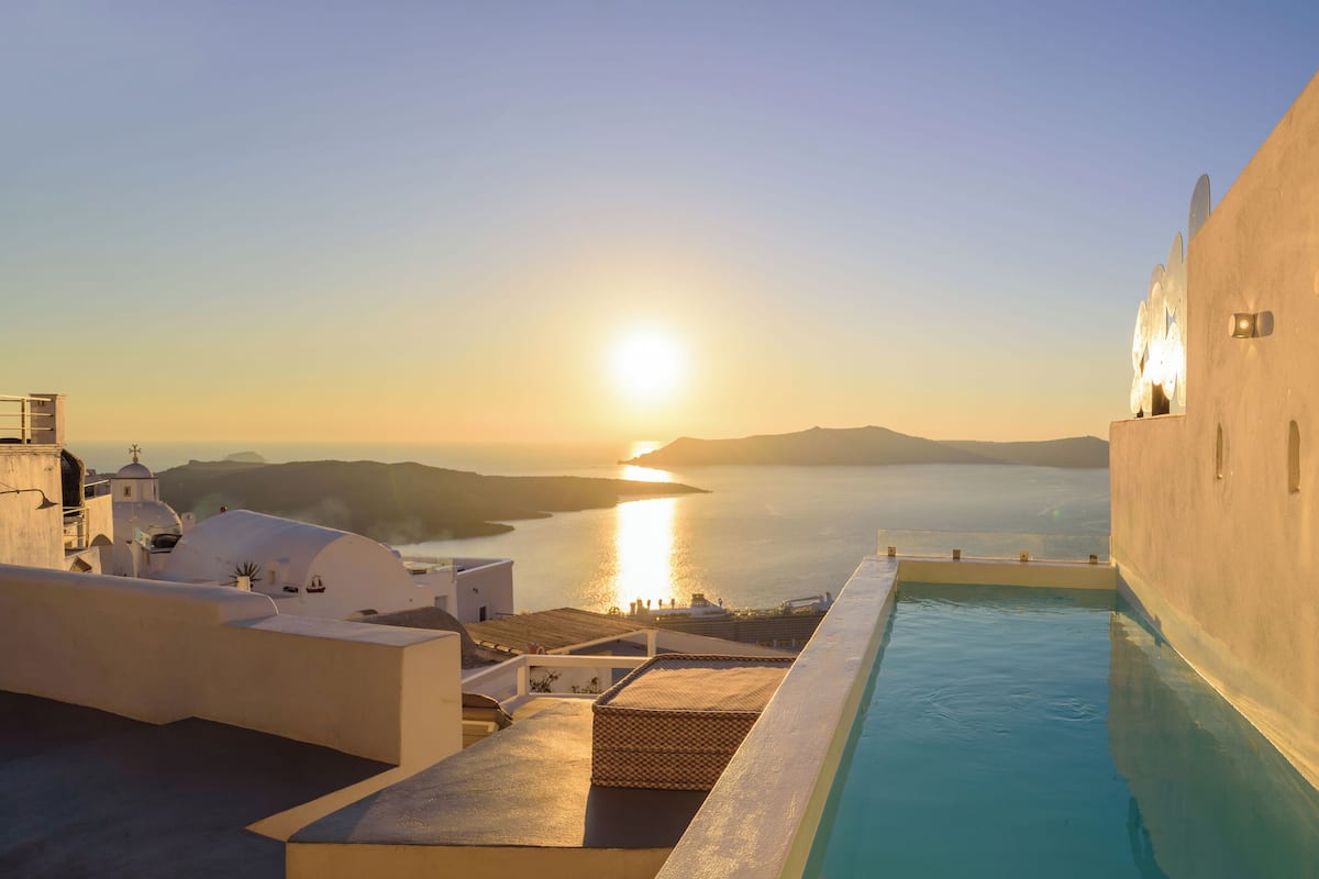A pool with a view of the sea and a sunset.