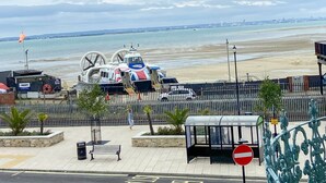 Vista costera con playa, estación de salvamento y paseo peatonal.