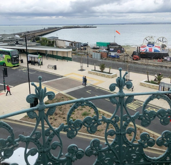 Un paseo marítimo con una línea de tranvía, una terminal de ferry y vistas al mar.