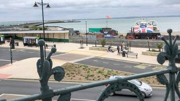 A coastal view with a beach, a lifeboat, and a pier in the background.