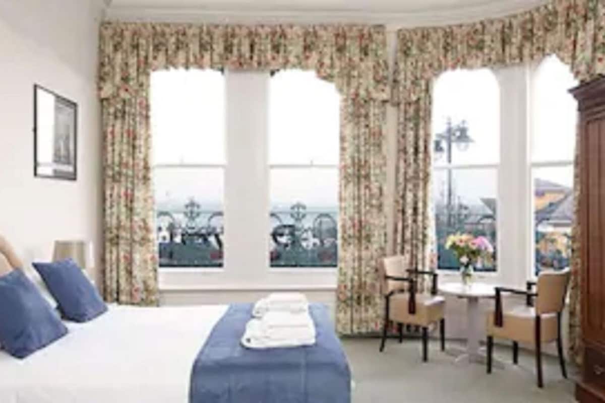 Una habitación de hotel con cama, escritorio y vistas de la ciudad.