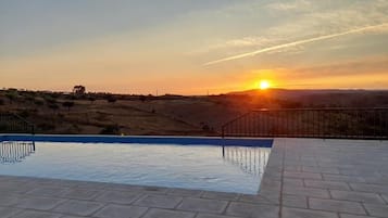 Una piscina al aire libre de temporada, sombrillas, tumbonas