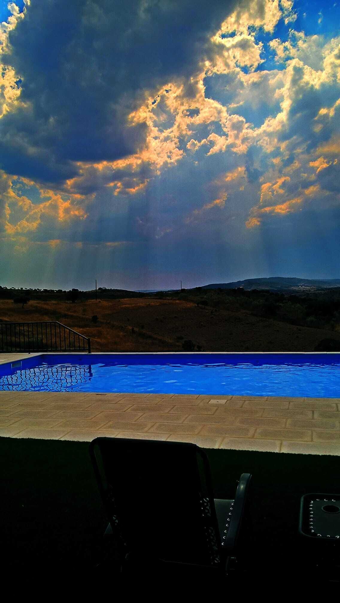 Una piscina al aire libre de temporada, sombrillas, tumbonas