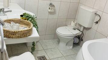 Une salle de bain avec des toilettes, un lavabo et une baignoire.