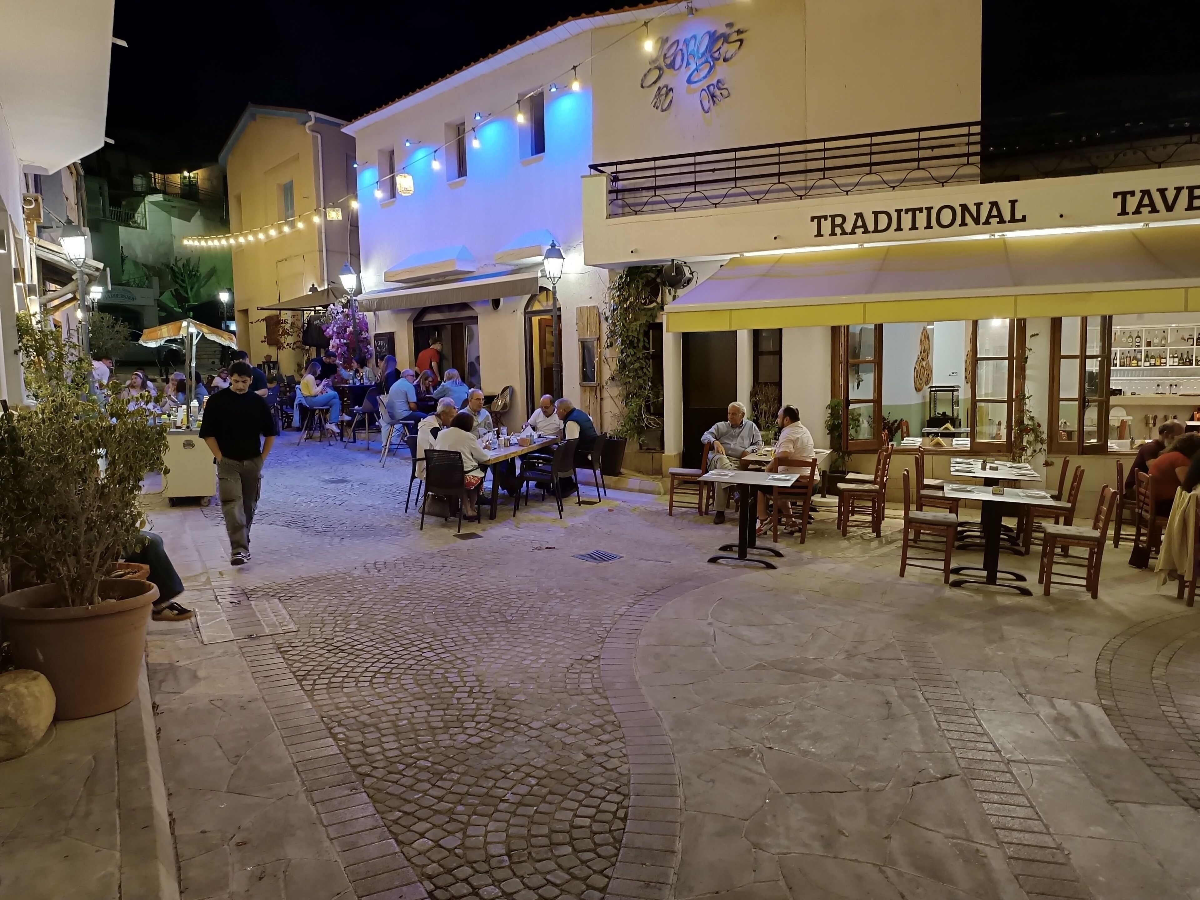 A traditional tavern with outdoor seating and a cobblestone street.
