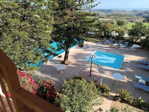 A pool area with lounge chairs and a view of the landscape.