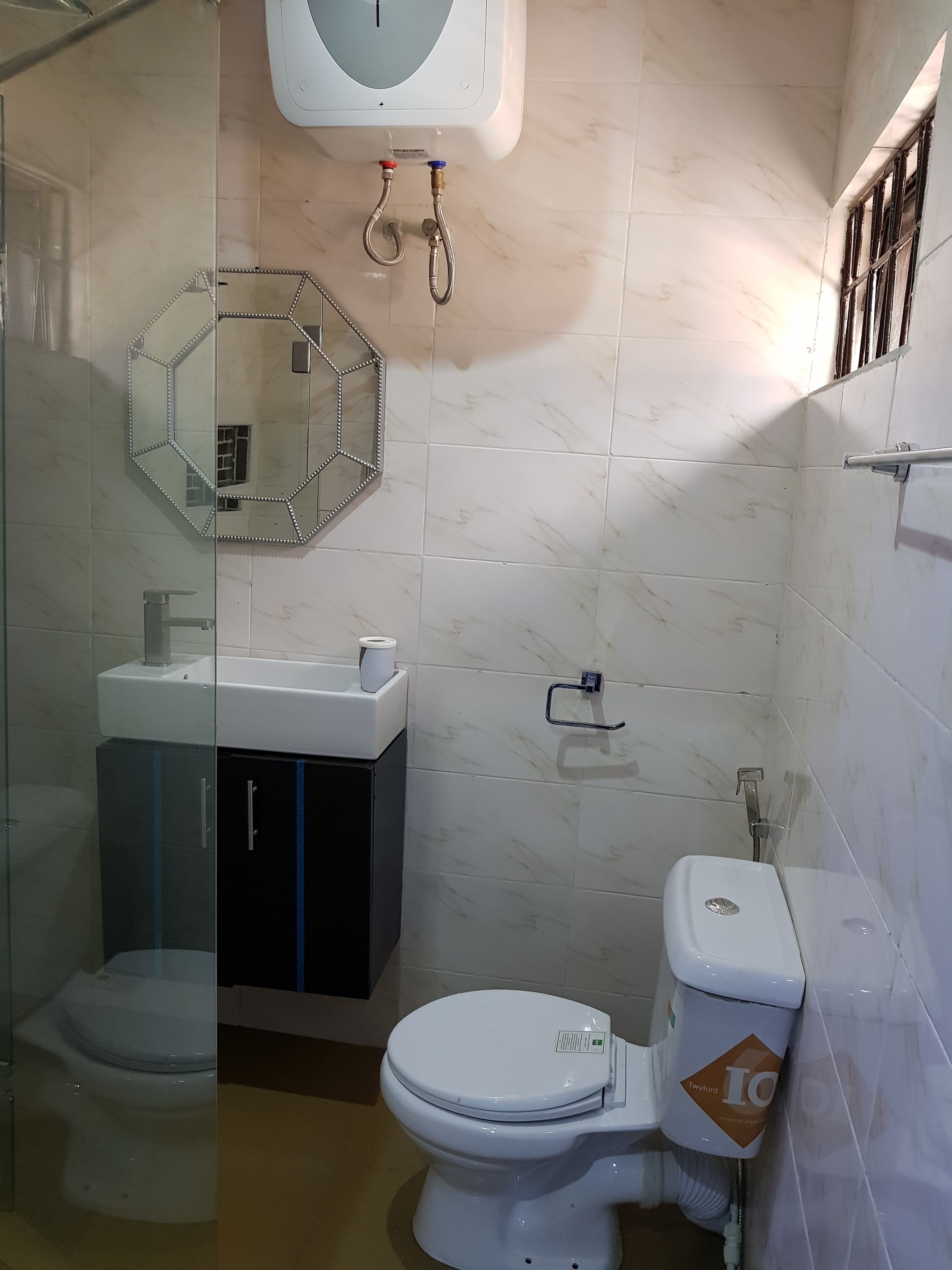 A bathroom with a toilet, a sink, and a shower.