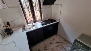 Een koelkast met diepvriezer, een microgolfoven, een kookplaat