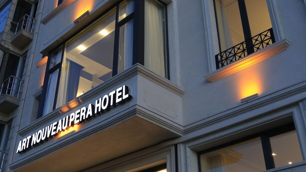 A multi-story hotel with illuminated windows and balconies. - Art Nouveau Pera (Istanbul)