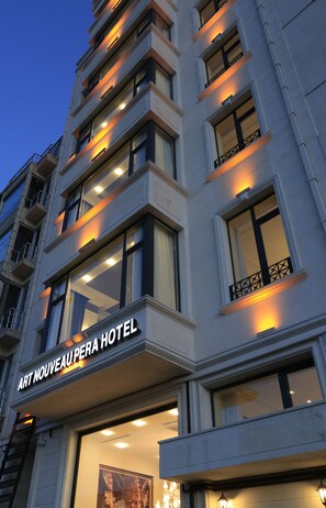 A multi-story hotel with illuminated windows and balconies. - Art Nouveau Pera (Istanbul)