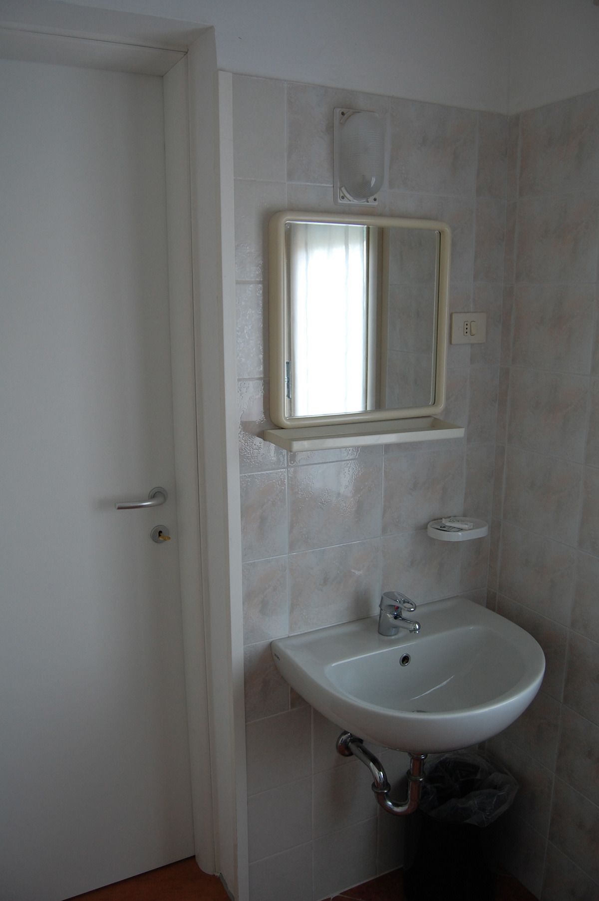 A bathroom with a white sink, a mirror, and a toilet.