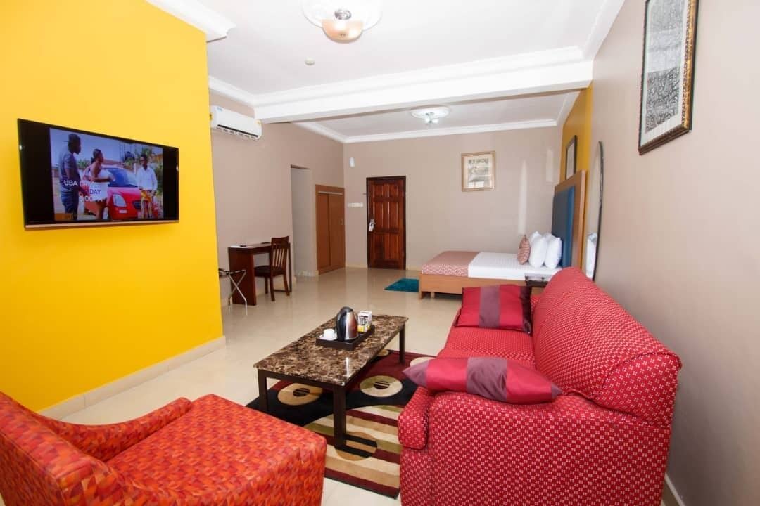 A living room with a TV, red patterned sofa, and a coffee table.