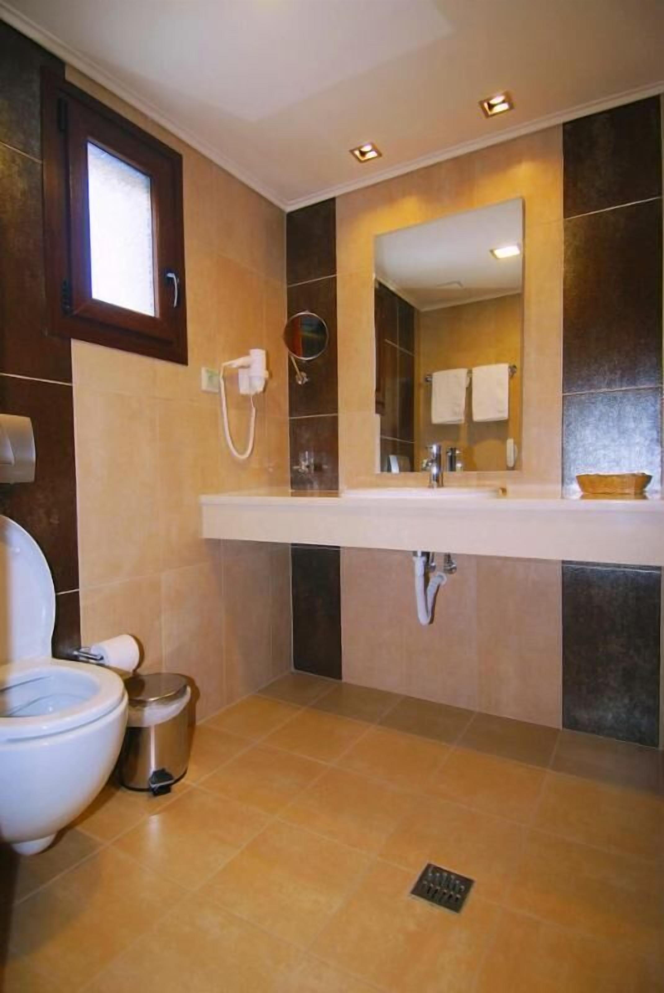 Une salle de bain comprenant des toilettes, un bidet et un lavabo avec un miroir au-dessus.