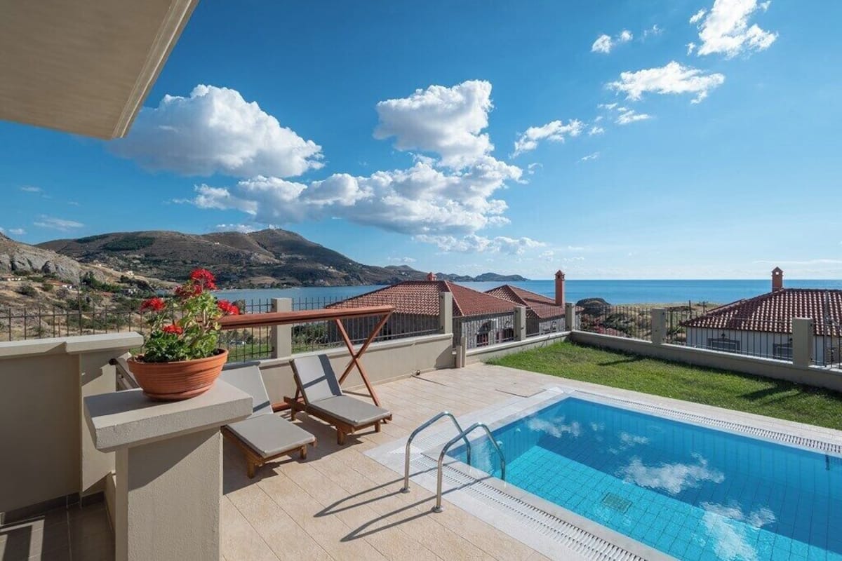 Ein Poolbereich mit Liegestühlen und Meerblick.