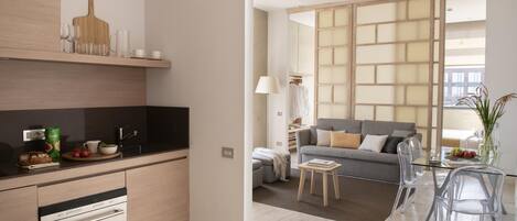 A modern kitchen with a built-in oven and a dining area with a glass table and chairs.