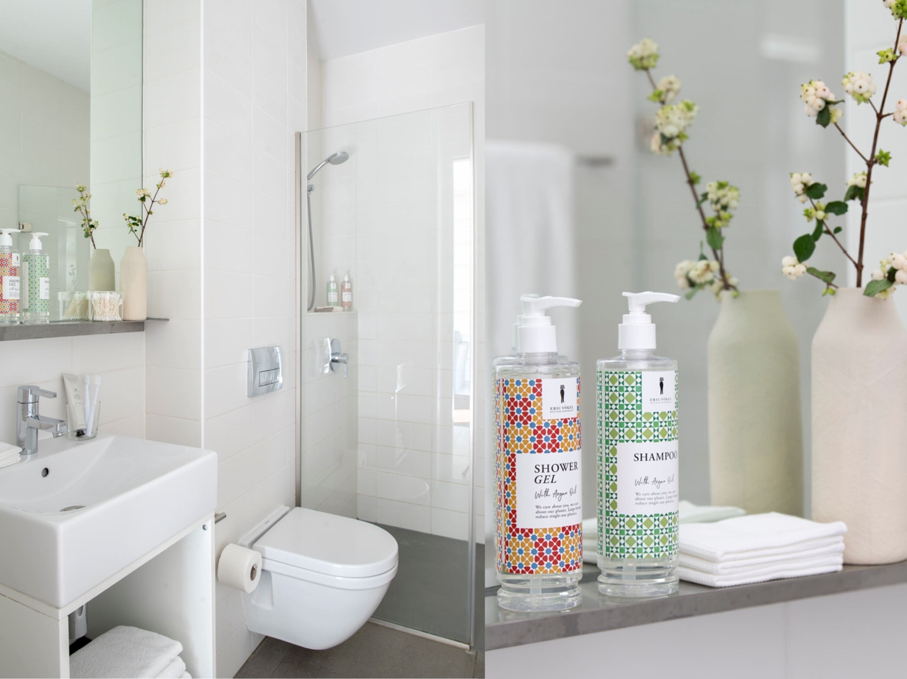 A modern bathroom with a toilet, sink, and shower. There are two bottles of shower gel and shampoo on the counter.