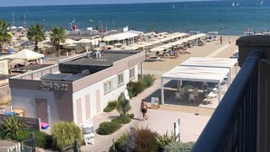 A beachside hotel with outdoor seating, a pool area, and a view of the sea. - Hotel Liberty Beach (Riccione)
