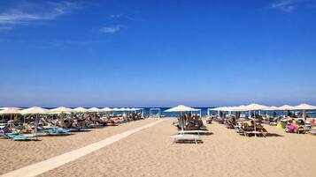 Praia particular, espreguiçadeiras, guarda-sóis